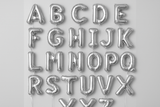Silver helium balloons in the shape of letters A through Z in a square format