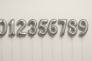 Silver helium balloons in the shape of numbers 0 through 9
