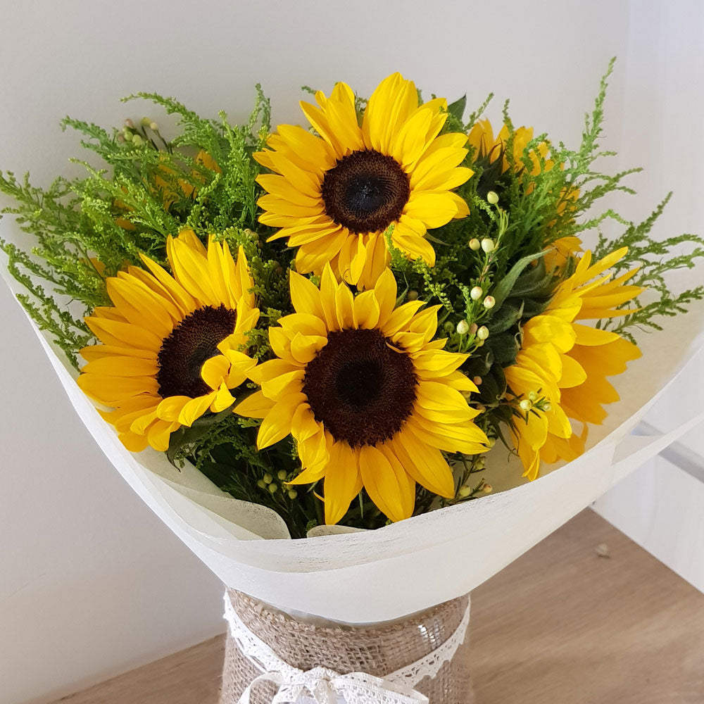 Bright SunFlower Hand Bouquet with vibrant yellow blooms and lush greenery in a rustic vase