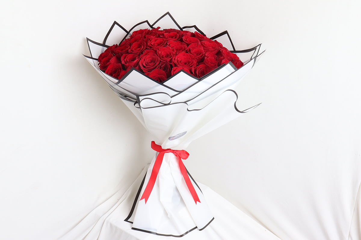Elegant Valentine Day bouquet featuring vibrant red roses with stylish black and white wrapping