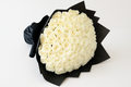 Bouquet of white roses wrapped in black paper on a white background